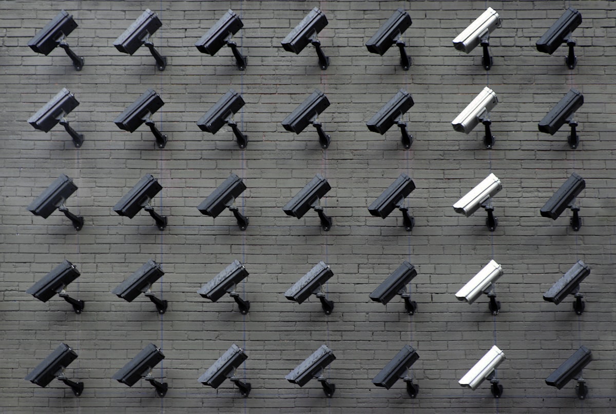 Grid of CCTV security cameras mounted on a wall